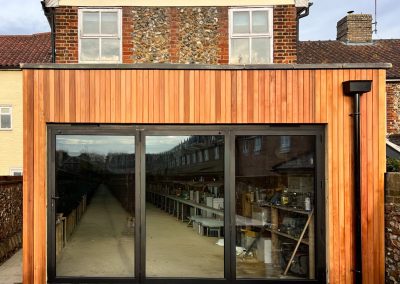 Oak-framed garage with timber cladding and a brick base