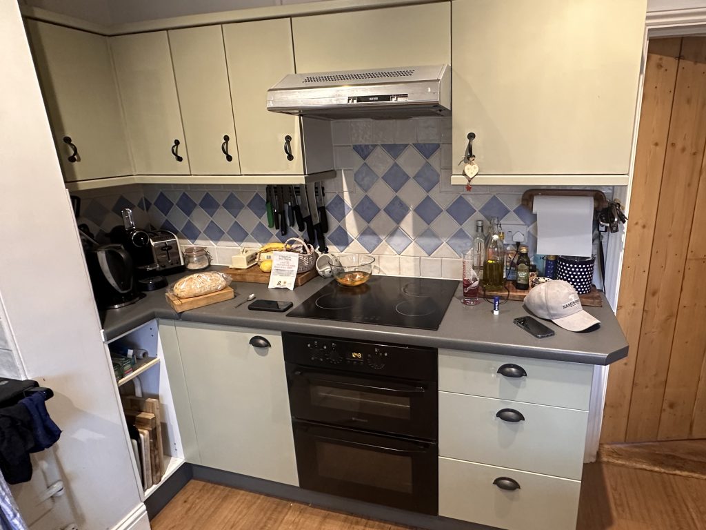 Dated kitchen before renovation, with light wood units