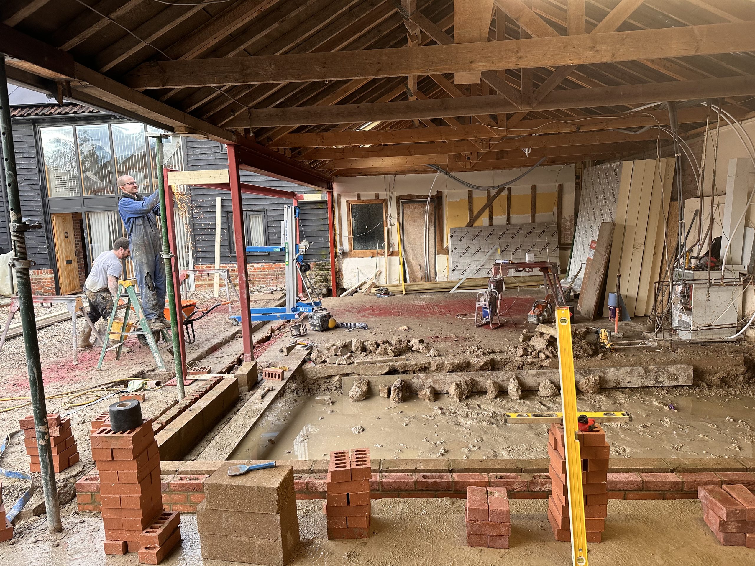 Open-plan barn interior with exposed oak roof trusses during renovation, Nedging Tye Open-plan barn interior with exposed oak roof trusses during renovation, Nedging Tye